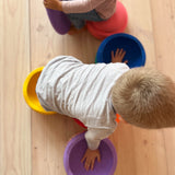 Ein Kind kniet in zwei Stapelsteinen, die Hände links und rechts stützt er ebenfalls in zwei umgedrehte Stapelsteine ab.