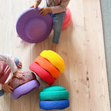 Stapelstein Regenbogen Classic 8 Steine und ein Confetti Stein sowie ein lila Balanceboard mit dem grad zeri Kinder spielen.