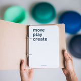 Das Ideenbuch zu Stapelstein "Move Play Create", zu sehen die erste Seite mit dem Titel, gehalten von zwei Händen.