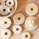 Die Scheiben des Baby Stapelturms von Kokomoo aus Holz liegen alle herum, teilweise auch in einem Jutekörbchen.