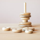 Der große Scheibenturm zum Stecken für Babys von Kokomoo: die Holzscheiben sind teilweise, nicht nach Größe geordnet, auf die Steckbasis geschoben, teilweise liegen sie noch davor.