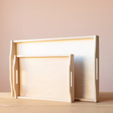 Die Tabletts in zwei verschiedenen Größen von Kokomoo, aufgestellt auf der langen Kante. Holzmaserung und Griffe sind gut zu sehen.