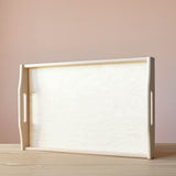 Das große Tablett aus Birkenholz von Kokomoo, aufgestellt auf der langen Kante. Holzmaserung und Griffe sind gut zu sehen.