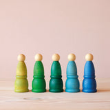 5 Grapat "Mates" Töpfchen aus Holz in Grün- und Blautönen, darauf stehen farblich passend Grapat Nins.