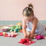 Das Pikler Tupfentuch von Kokomoo wird von einem Kind als Betten ür ihre kleinen Stoffpuppen benutzt.