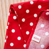 Das Pikler Tupfentuch in rot mit weißen Punkten. Das Etikett von Kokomoo ist zu sehen.