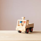 Der Fagus Unimog aus Holz von vorne fotografiert, im Führerhaus sitzen die beiden Fagus Holzfiguren mit rotem und blauem Kopf.