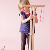 Ein Kind hält den zugeklappten Wäscheständer von Glückskäfer.