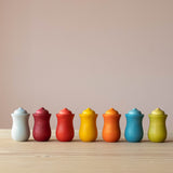 Die sieben Nins Holzfiguren vom Set Grapat 7 Moons stehen in einer Reihe in ihren sieben Holzbechern, von links beginnend mit Montag.