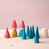 Von Grapat "Nins Tomten" Zwergenwelt Spielset sind zwei Holzzwerge, 1 roter Mandala Stein Feuer, sechs blaue Mandala Kegel und 5 Mandala Holzplättchen zu sehen.