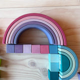 Die Boegen des großen Regenbogen Pastell von Grimms in lila- und blau-Toenen, zusammengelegt mit den farblich passenden Würfeln vom Grimms Mosaik.
