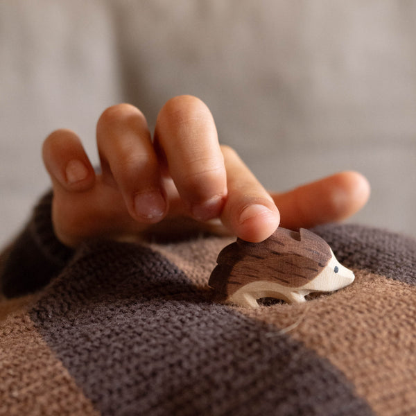 Eine Kinderhand berührt den kleinen Holzigel von Ostheimer an seinen "Stacheln".
