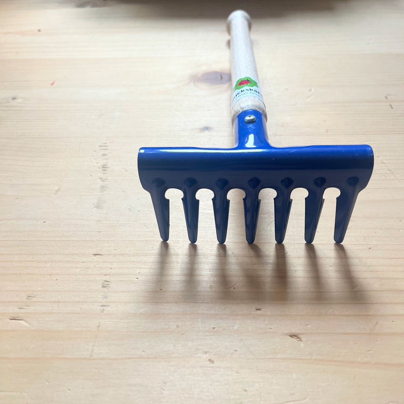 Der blaue Metallrechen von Glückskäfer für Kinder von nahem fotografiert, sodass die Verarbeitungsdetails gut zu sehen sind.