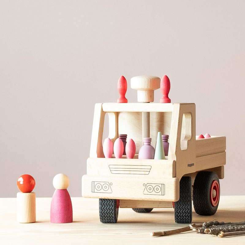 Der Fagus Unimog aus Holz hat viel Mandala Legematerial in rosa aufgeladen.