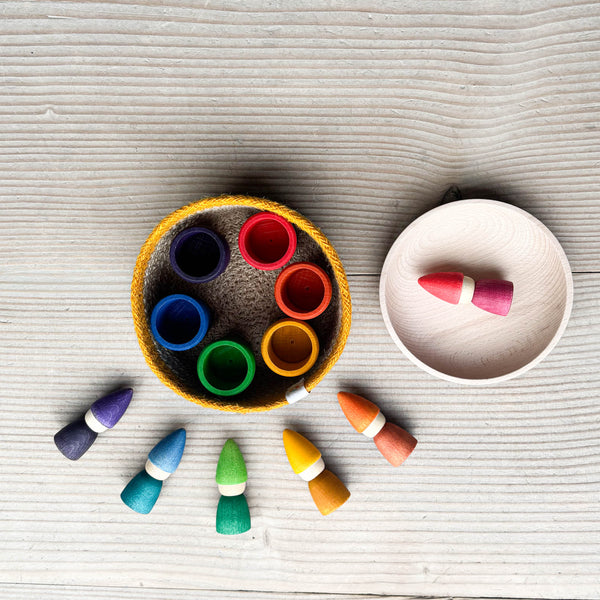 Das Kokomoo Bunte Zwerge Spielset für Babys ab 1 Jahr. Im Jutekorb sind die Grapat Mates Holztöpfchen, rundherum liegen die Grapat Tomtens Holzzwerge, der rote kleine Zwerg liegt in der Holzschale.