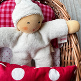 Ein weißer Nanchen Wichtel kuschelt im Wichtelnest Puppenbett von Kokomoo.