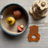 Ein Geschenkseit für Babys ab 1 Jahr: In einem Jutekörbchen liegen Grapat "Little Things" in gelb und braun, daneben eine Baby Beißring Kleiner Panda aus Naturkautschuk und ein kleiner Steckturm aus Holz.