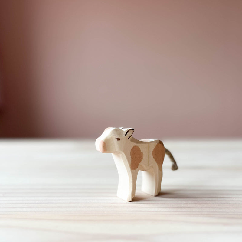 Ostheimer Holzfigur Kalb zum Spielen in braun leicht nach vorne gedreht stehend mit Blick nach links.