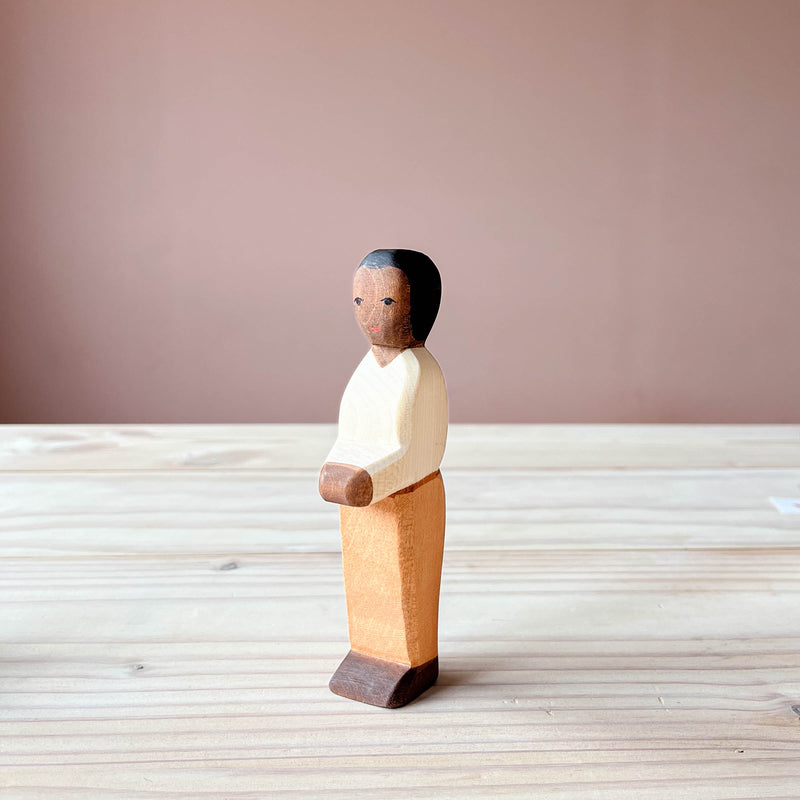 Die Ostheimer Spielfigur Vater aus Holz steht auf einer Holzplatte und schaut schräg nach vorne.