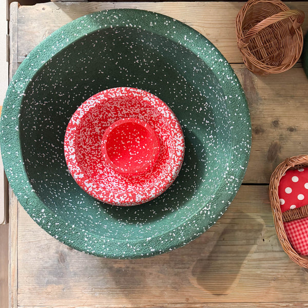 Blick von oben auf 3 verschieden große, ineinander liegende, gesprenkelte Stapelstein in rot, grün, weiss