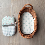 Links die Puppenbettwäsche für das Wichtelnest, rechts das Wichtelnest Puppenbett mit hellblau getupfter Matratze.