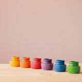 In 6 Grapat Schälchen in Regenbogenfarben stehen die farblich passenden Töpfchen Grapat "Mates".