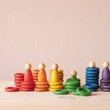 Grapat "Nins, Rings & Coins" buntes Holzfiguren-Set teilweise aufeinander gestapelt und nebeneinander aufgestellt.