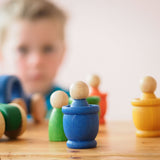 Ein blaues Grapat Mates Holztöpfchen, darin ist ein blaue Holzfigur versteckt.