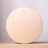 Die große, runde Holzplatte "Construction Base Platform" von Grapat stehend auf der Kante.