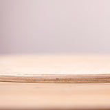 Der Schichtaufbau der großen, runden Holzplatte "Construction Base Platform" von Grapat von nahe fotografiert.